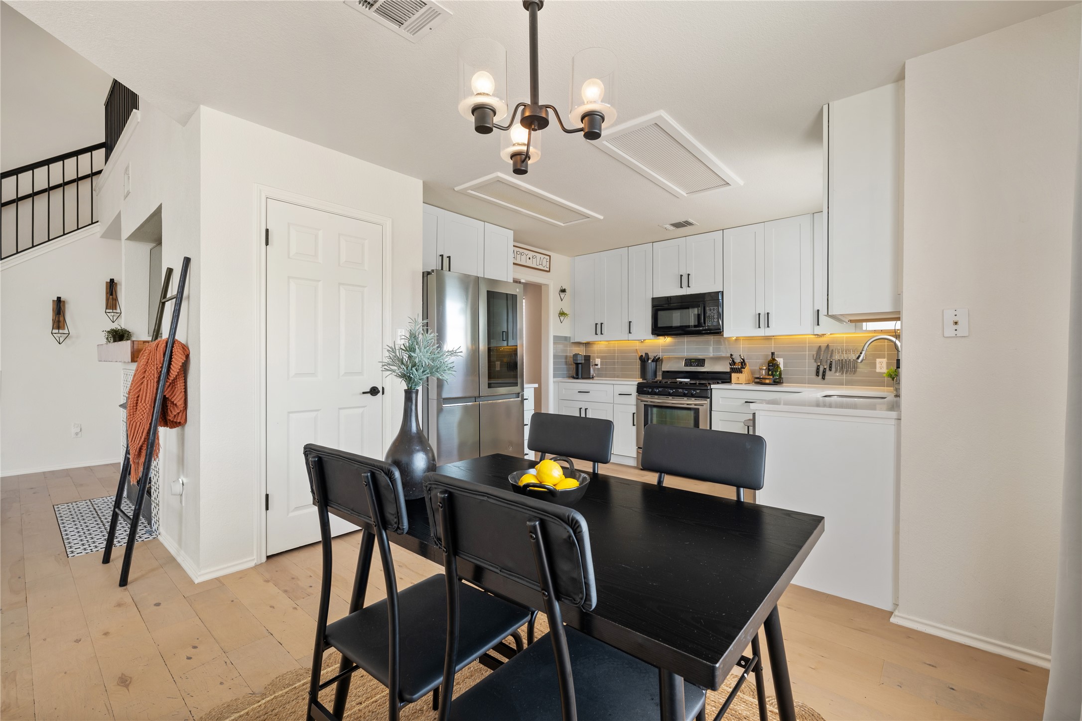 9257 Vigen Circle Austin, TX 78748 - Photo 11 of 33 a kitchen with stainless steel appliances granite countertop a dining table chairs refrigerator and microwave