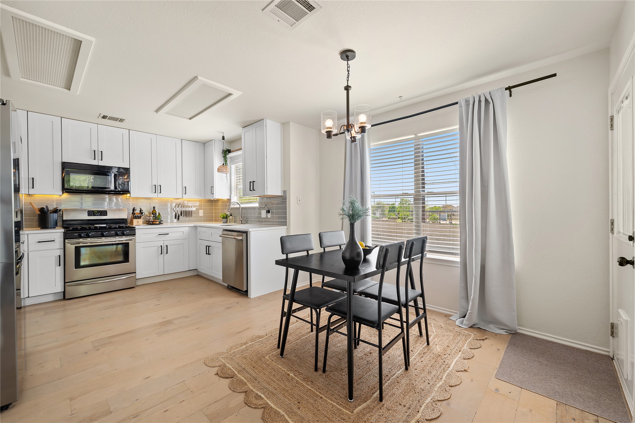 9257 Vigen Circle Austin, TX 78748 - Photo 10 of 33 a kitchen with a table chairs refrigerator and microwave