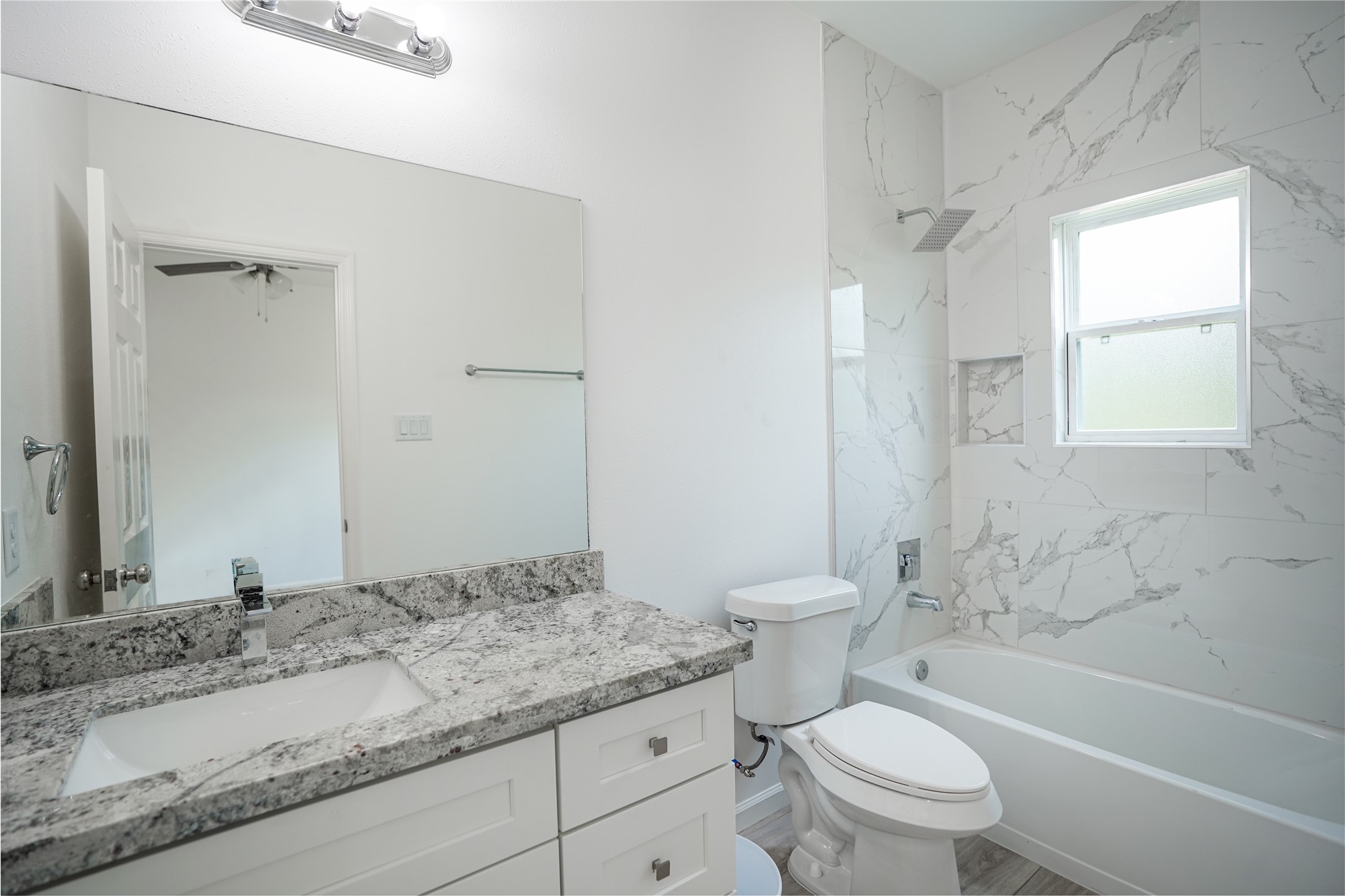 7914 Laura Koppe Road, Unit A Houston, TX 77028 - Photo 11 of 14 a bathroom with a granite countertop toilet a sink and a bathtub
