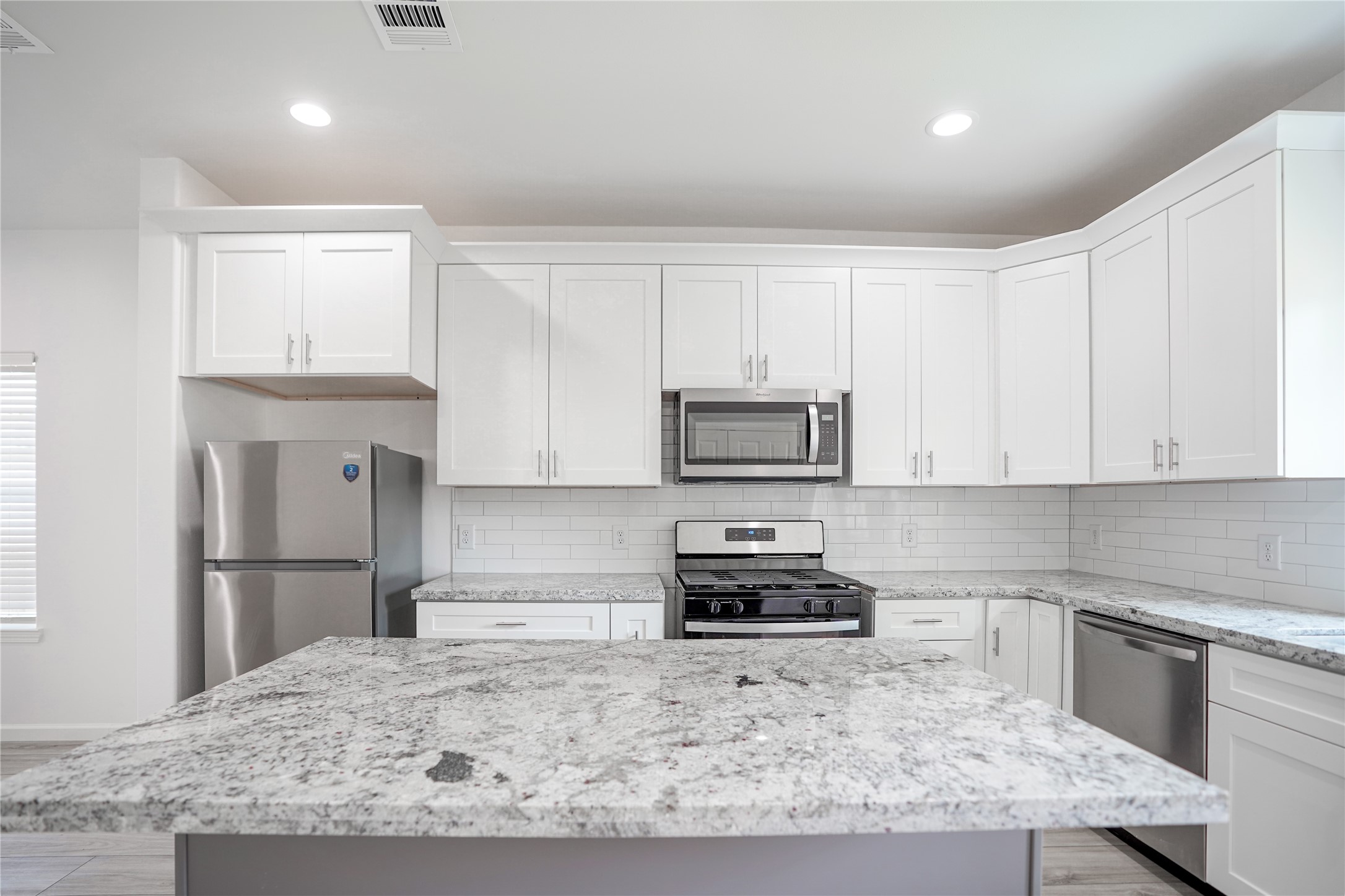 7914 Laura Koppe Road, Unit A Houston, TX 77028 - Photo 4 of 14 a kitchen with kitchen island granite countertop a refrigerator stove top oven and sink