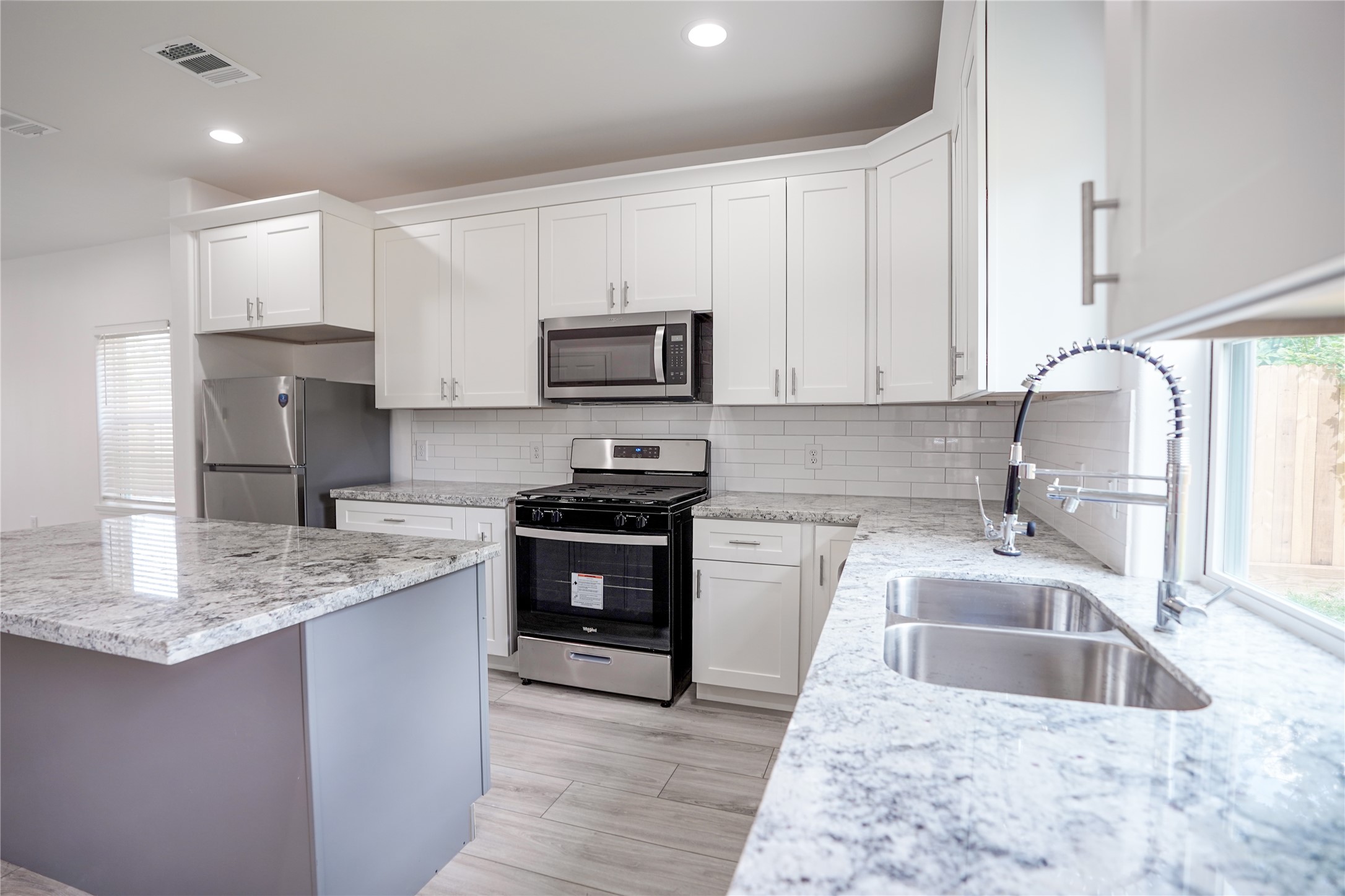 7914 Laura Koppe Road, Unit A Houston, TX 77028 - Photo 5 of 14 a kitchen with kitchen island granite countertop a sink stove microwave and refrigerator