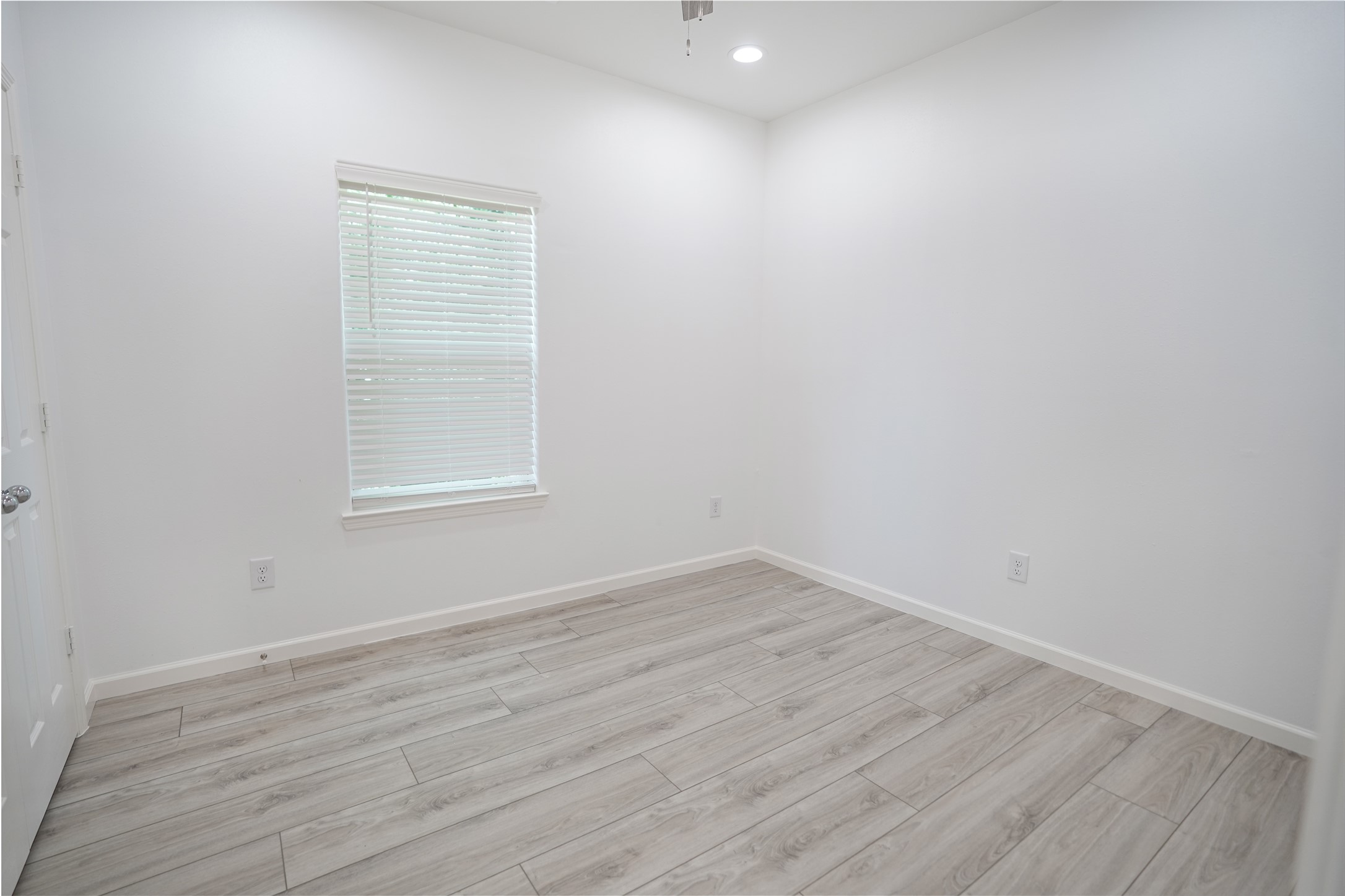 7914 Laura Koppe Road, Unit A Houston, TX 77028 - Photo 9 of 14 an empty room with wooden floor and windows