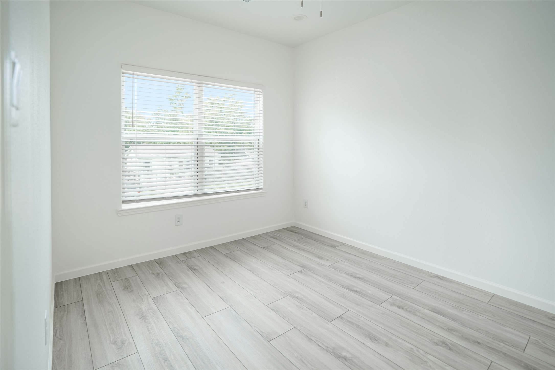 7914 Laura Koppe Road, Unit A Houston, TX 77028 - Photo 10 of 14 an empty room with wooden floor and windows