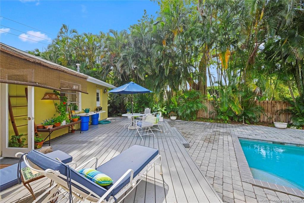 111 South Sewalls Point Road Stuart, FL 34996 - Photo 42 of 60 a view of a patio with table and chairs under an umbrella with wooden floor
