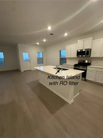 a view of kitchen with stainless steel appliances granite countertop lots of white cabinets