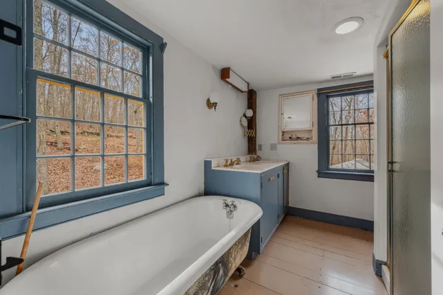 a view of empty room with wooden floor and fireplace