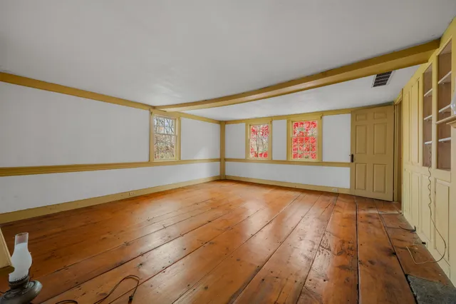 a view of empty room with wooden floor and fireplace