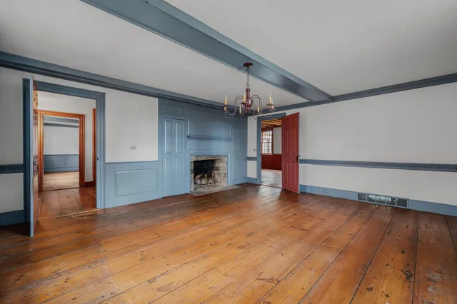 a view of empty room with wooden floor and fireplace