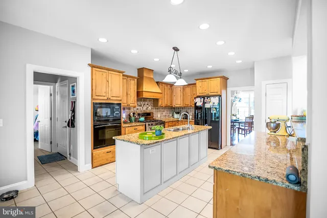 a kitchen with stainless steel appliances granite countertop a sink and a refrigerator