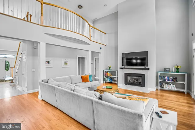 a living room with furniture and a fireplace with wooden floor