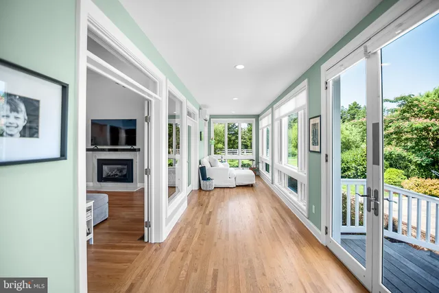 a view of a hallway with wooden floor and a living room