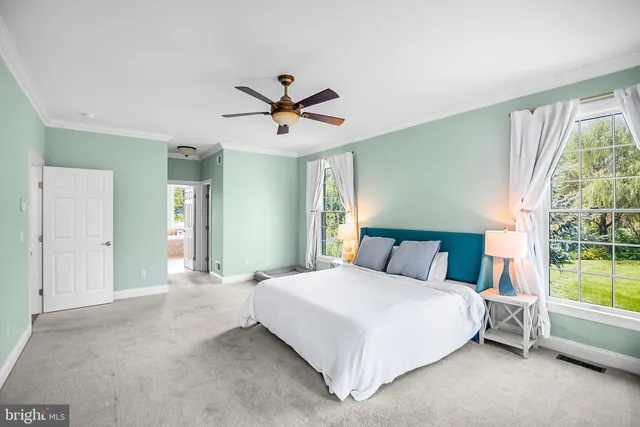 a bedroom with a large bed and a chandelier