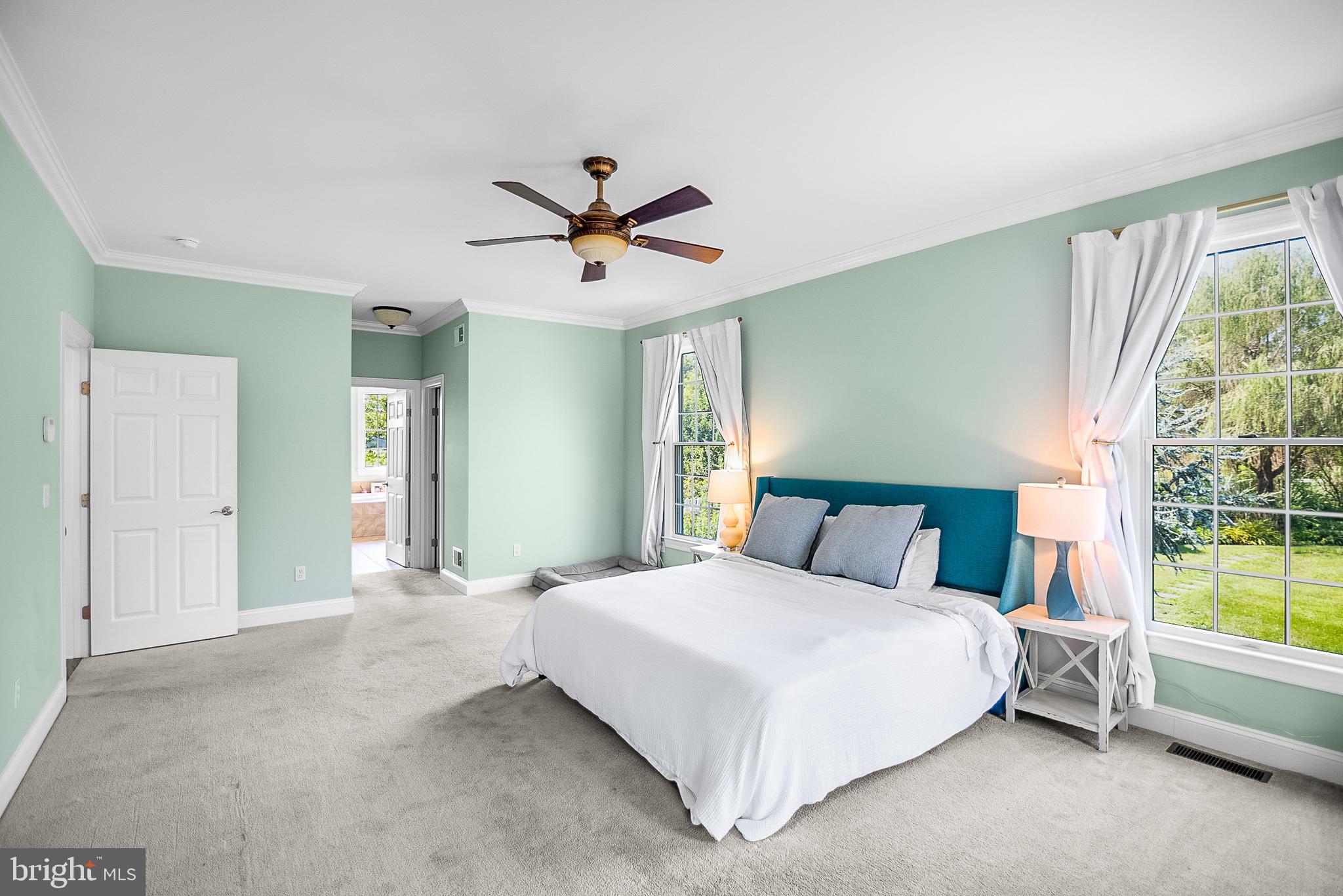 26604 East Bonfield Road Oxford, MD 21654 - Photo 21 of 44 a bedroom with a large bed and a chandelier