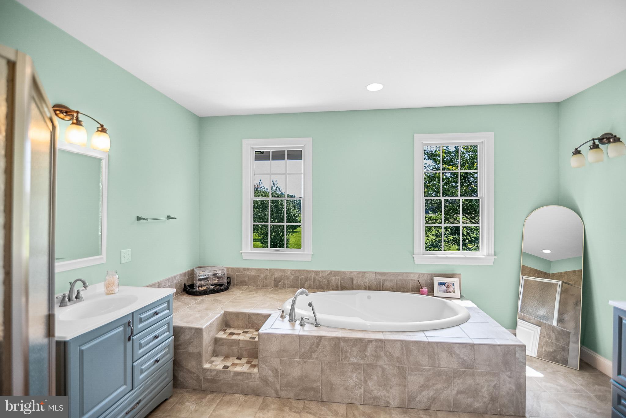 26604 East Bonfield Road Oxford, MD 21654 - Photo 24 of 44 a bathroom with a tub sink and mirror