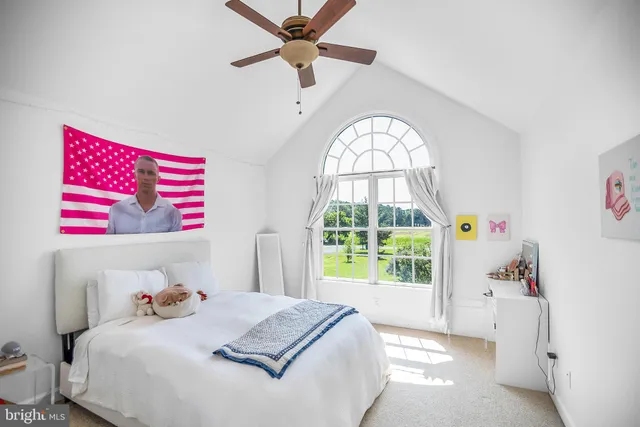a bedroom with a bed and a large window