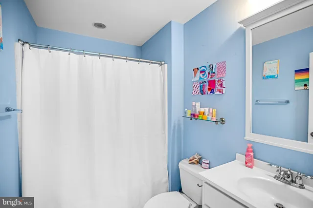 a bathroom with a sink vanity mirror and toilet
