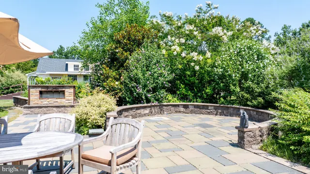 a patio with table and chairs and potted plants