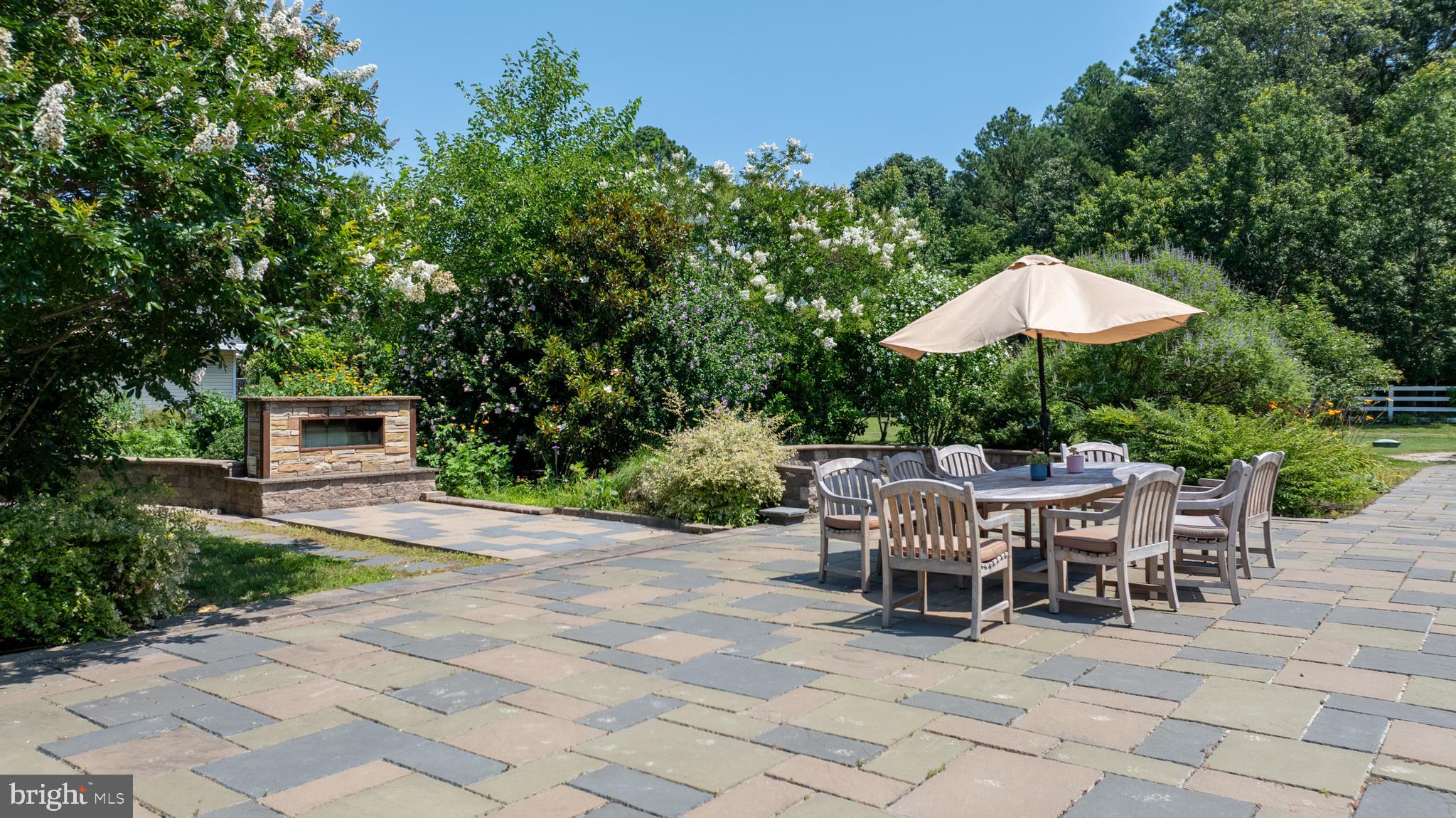 26604 East Bonfield Road Oxford, MD 21654 - Photo 35 of 44 a view of a patio with table and chairs potted plants and a large tree