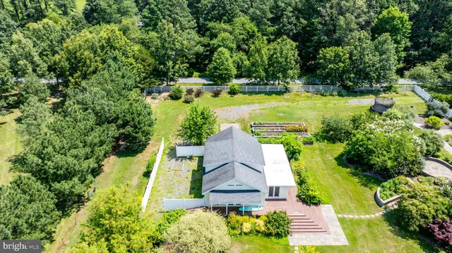 an aerial view of a house with swimming pool a yard and lake view