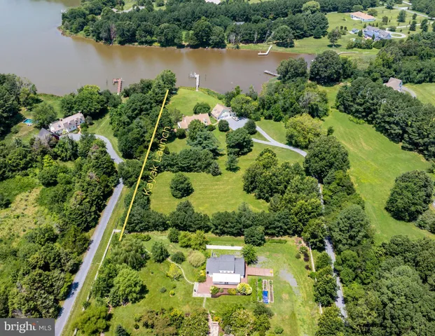 an aerial view of a house with a yard and lake view