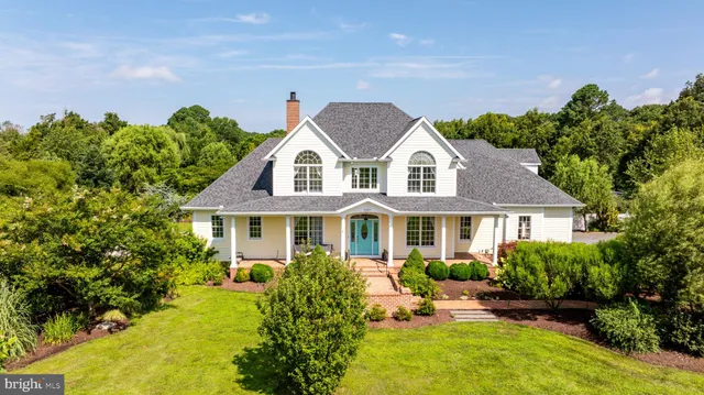 a front view of a house with a yard and potted plants
