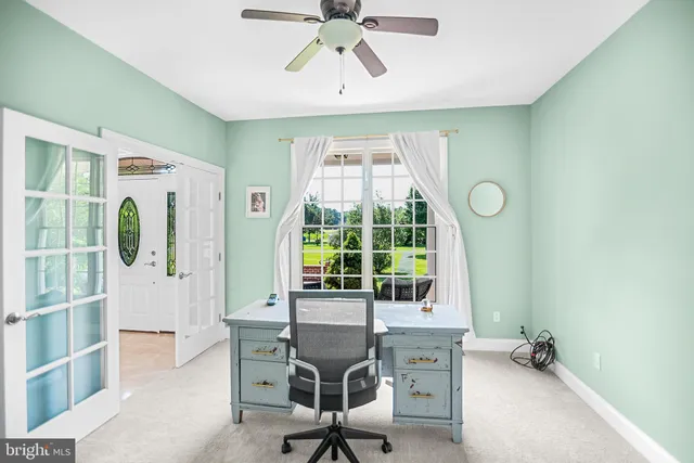 a view of a workspace with furniture and a window