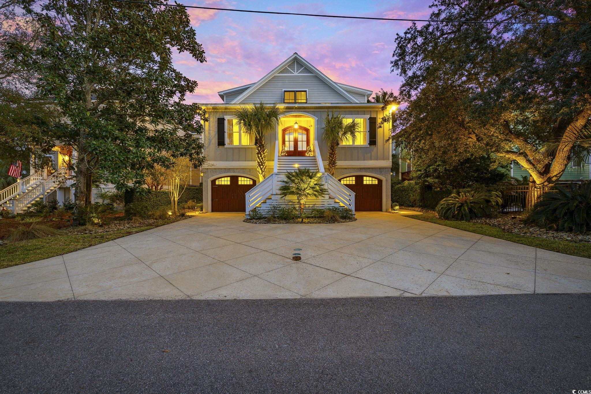 Coastal home featuring stairway, driveway, and a garage