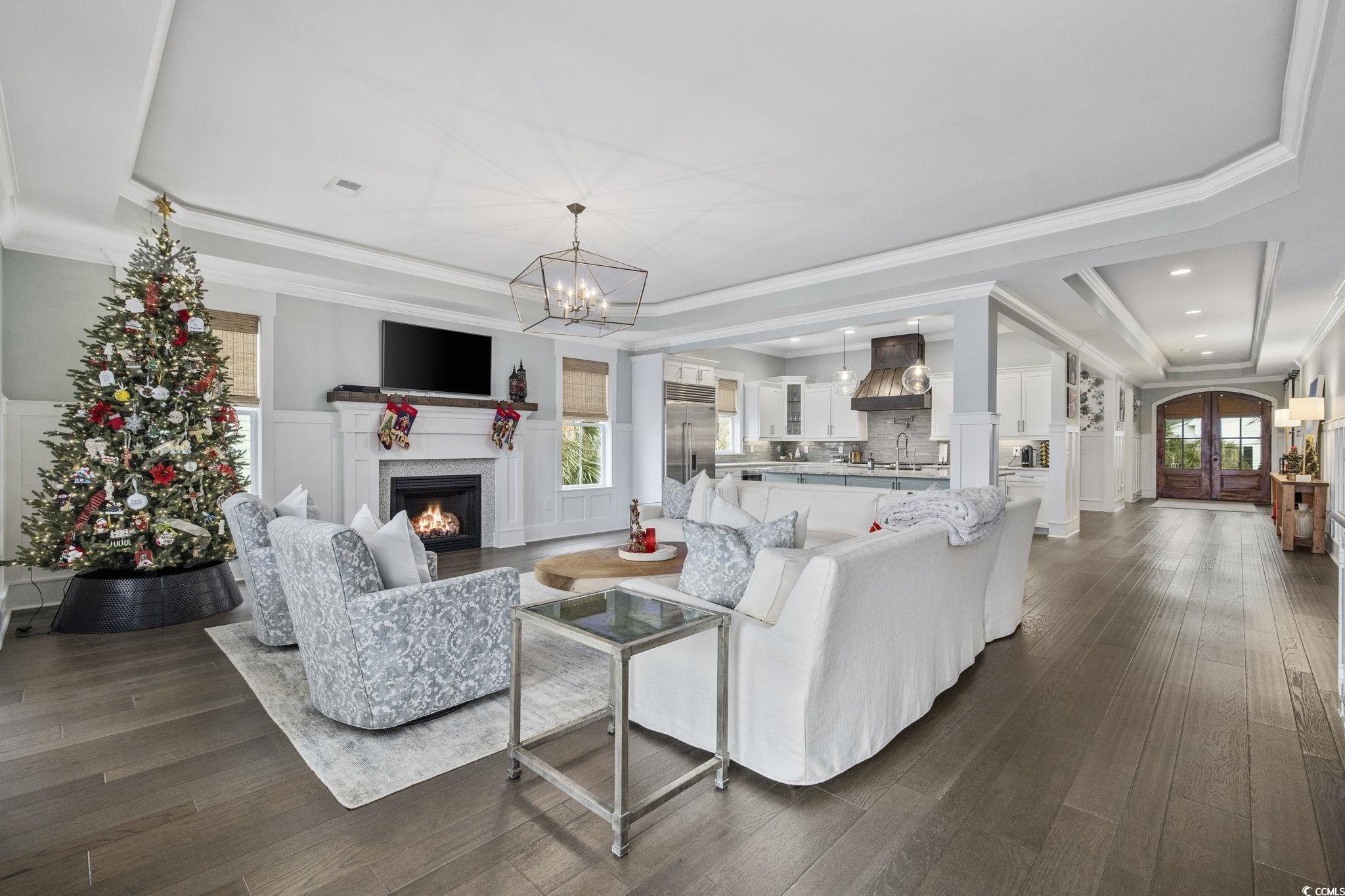 636 North Creekside Drive Murrells Inlet, SC 29576 - Photo 10 of 40 Living area with crown molding, a tray ceiling, plenty of natural light, a decorative wall, and wainscoting