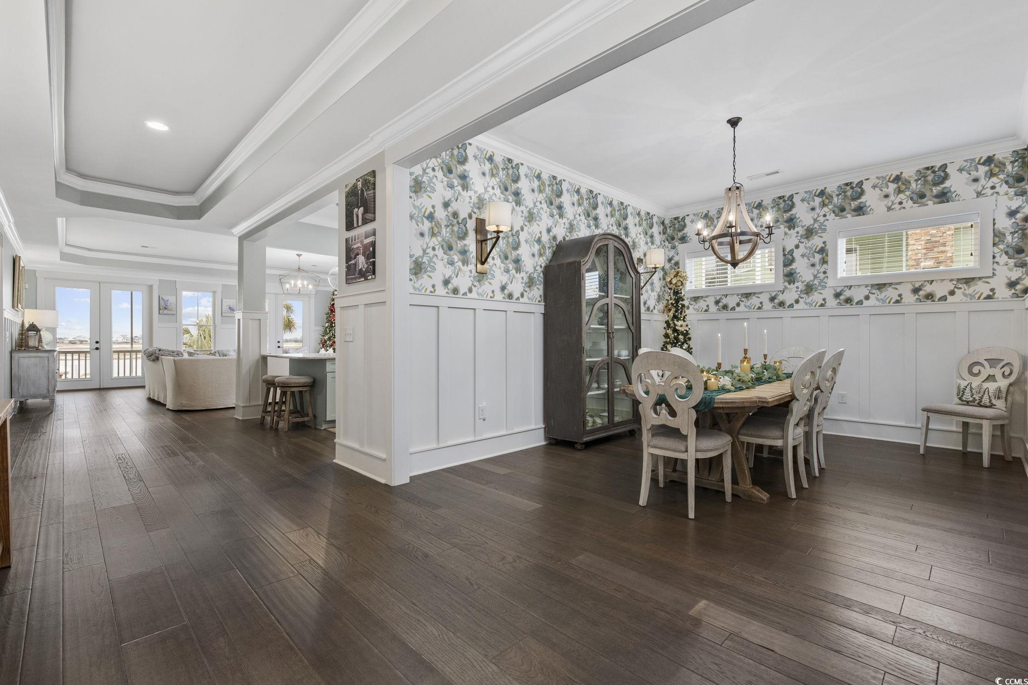 636 North Creekside Drive Murrells Inlet, SC 29576 - Photo 6 of 40 Dining space featuring a chandelier, wainscoting, wallpapered walls, dark wood finished floors, and a decorative wall