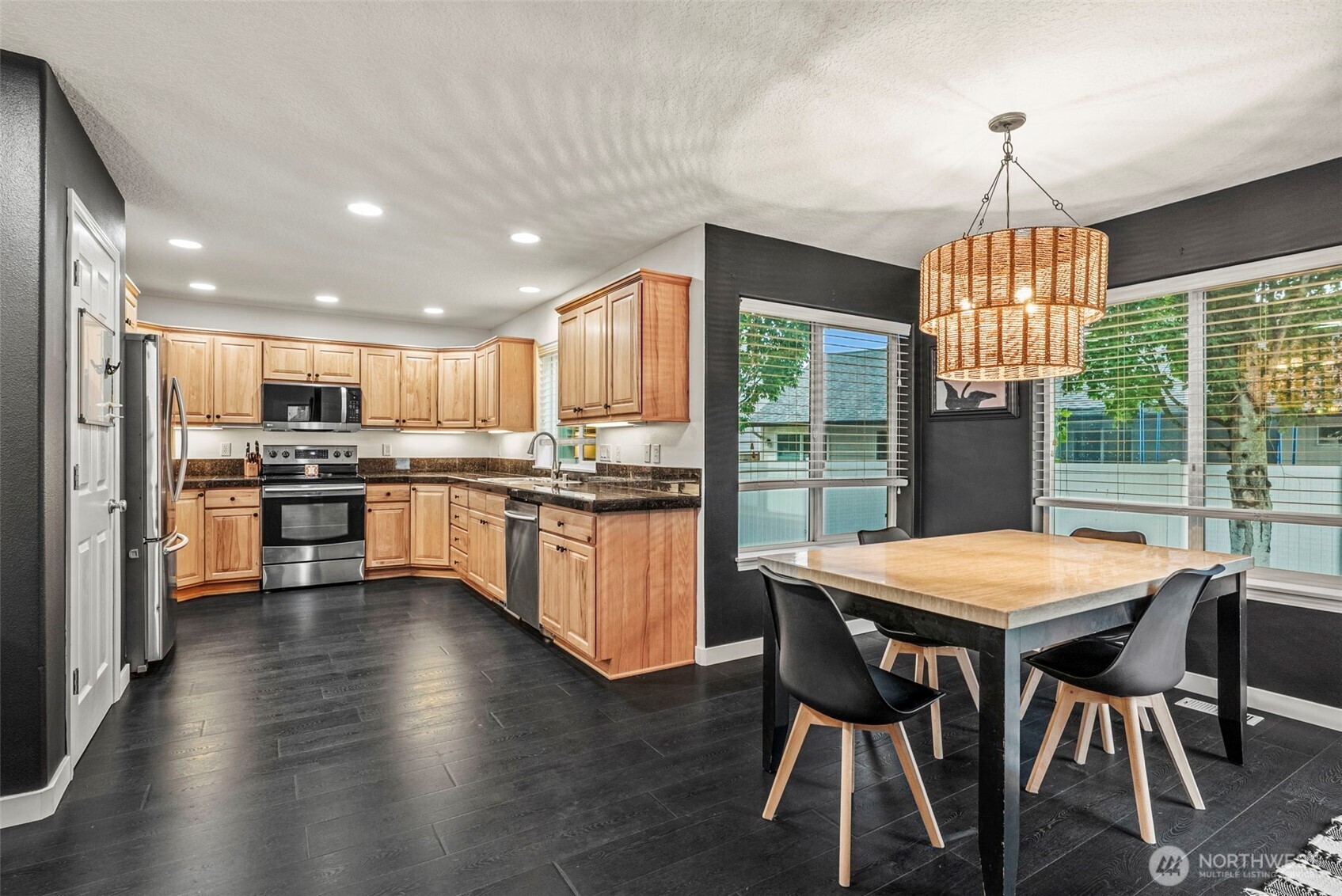 70 Crown Point Road Longview, WA 98632 - Photo 5 of 33 a kitchen with stainless steel appliances granite countertop a stove top oven a sink dishwasher a dining table and chairs with wooden floor