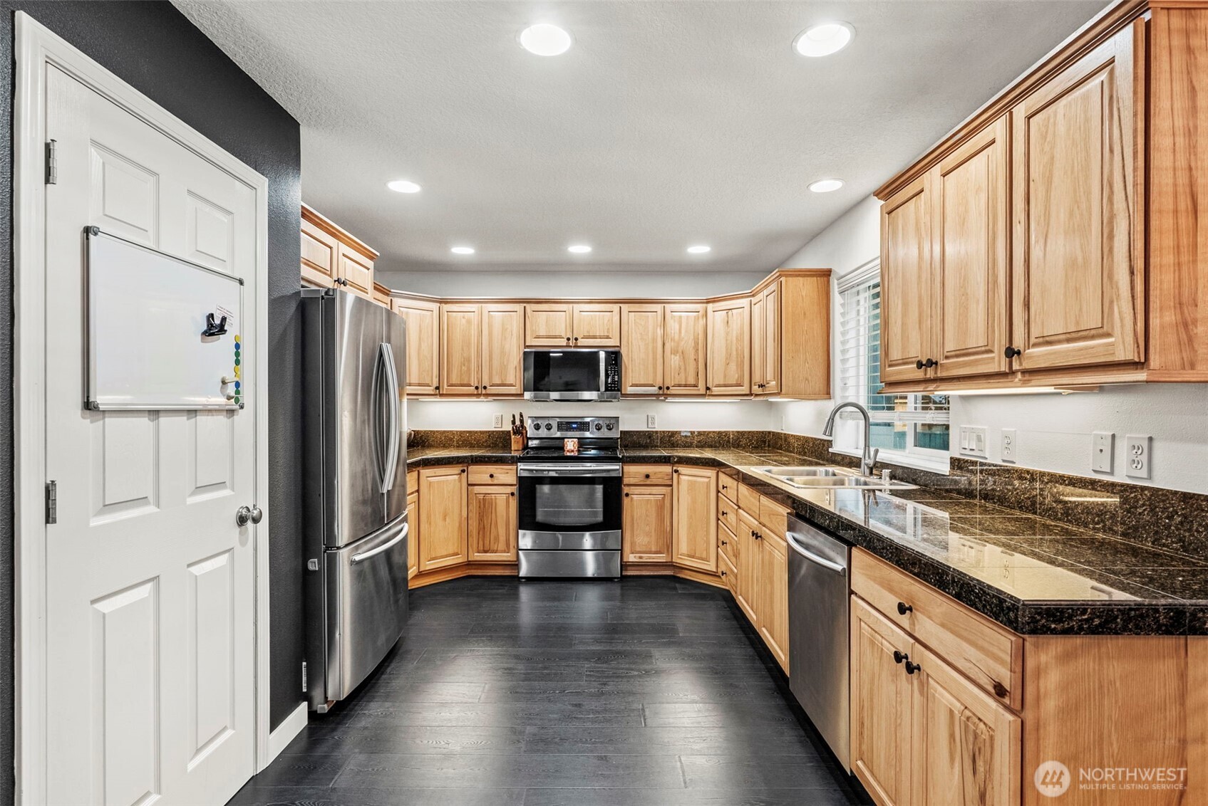 70 Crown Point Road Longview, WA 98632 - Photo 7 of 33 a large kitchen with stainless steel appliances granite countertop a refrigerator a sink dishwasher a stove and white cabinets with wooden floor