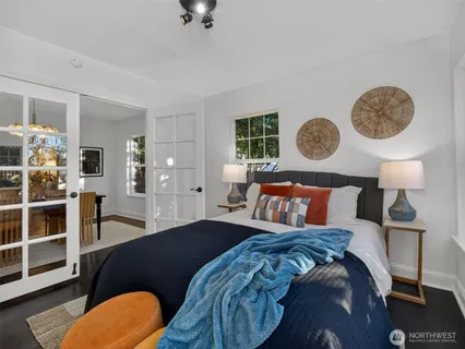 a bedroom with a bed and painting on the wall