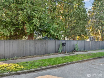 a view of a backyard with potted plants and wooden fence