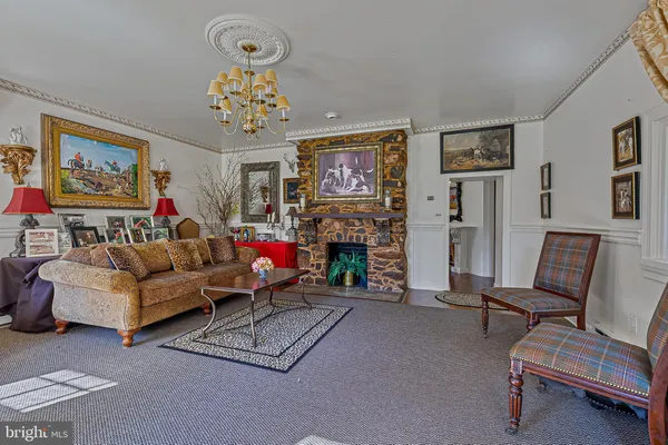 a living room with furniture a fireplace and a chandelier