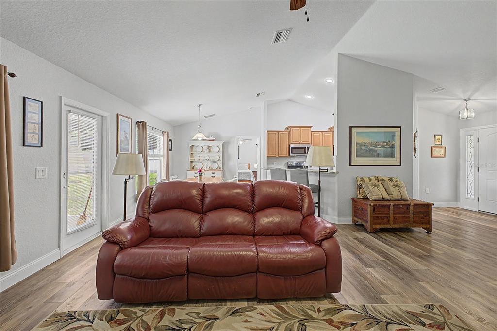 11213 Flock Avenue Weeki Wachee, FL 34613 - Photo 15 of 46 a living room with furniture ceiling fan and a wooden floor
