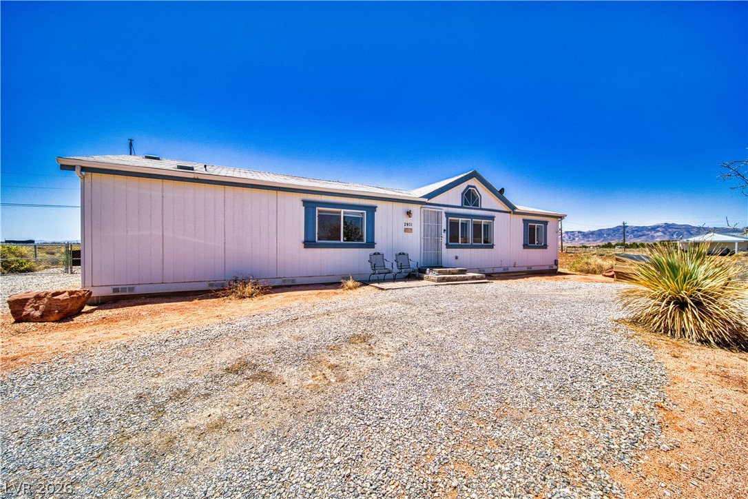 2931 Rio Rancho Drive, Unit 4 Pahrump, NV 89048 - Photo 20 of 21 A tranquil desert retreat offers a simple exterior with gravel parking and distant mountain vistas.
