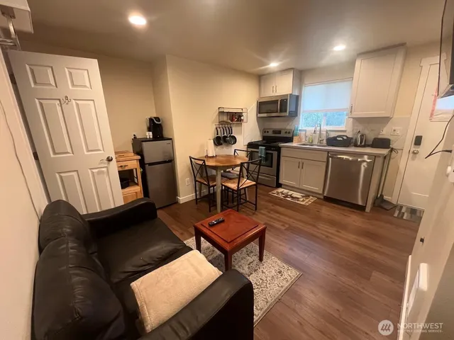 a living room with furniture and a dining table with kitchen view