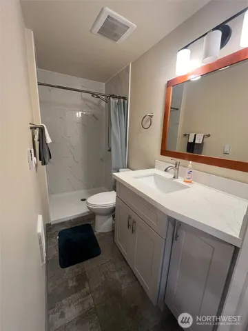 a bathroom with a sink a toilet and shower