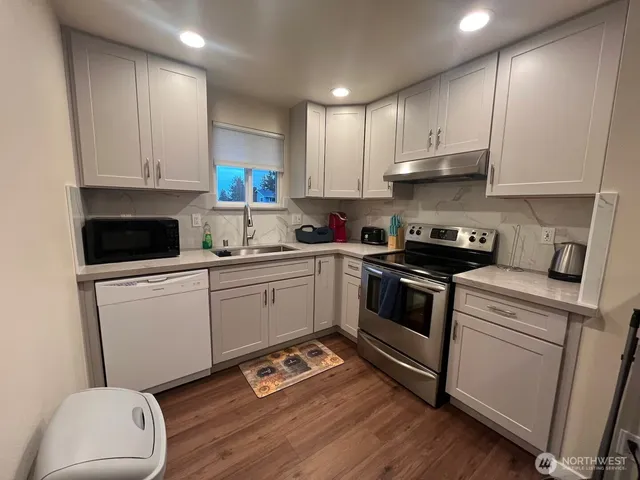 a kitchen with a sink a stove and cabinets