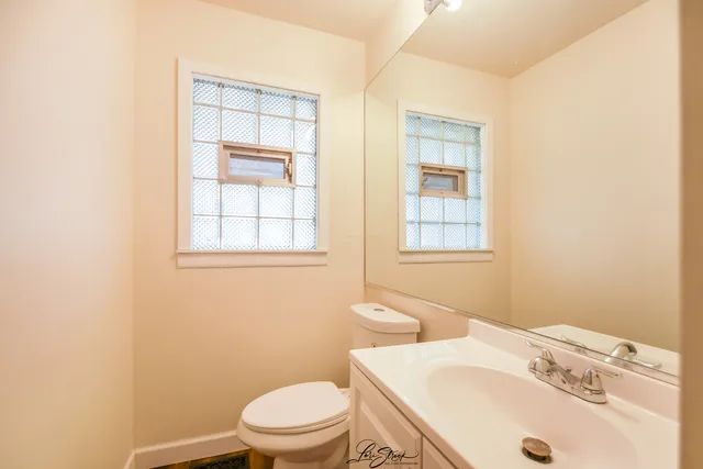 a bathroom with a sink a toilet and a window