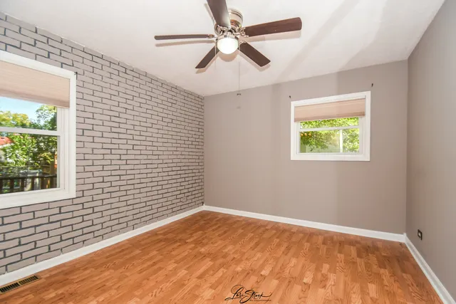 an empty room with a window and a ceiling fan