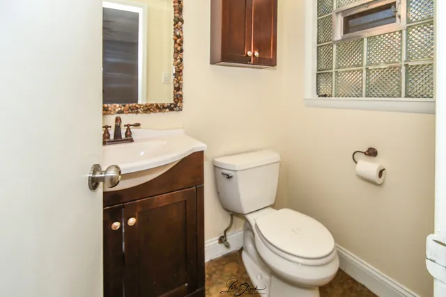 a bathroom with a toilet a sink and a mirror
