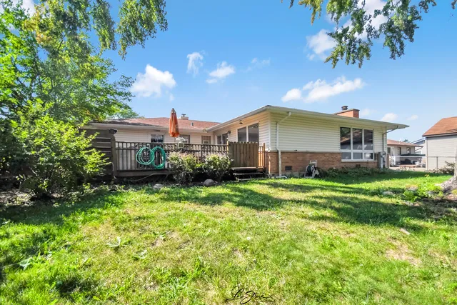 a view of a house with a big yard plants and large trees