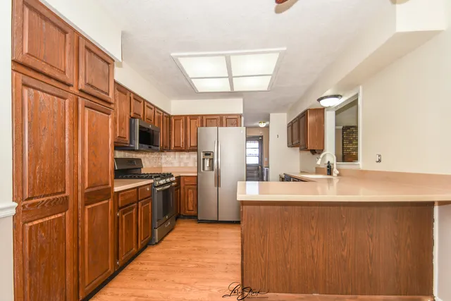 a kitchen with stainless steel appliances granite countertop a refrigerator and a sink