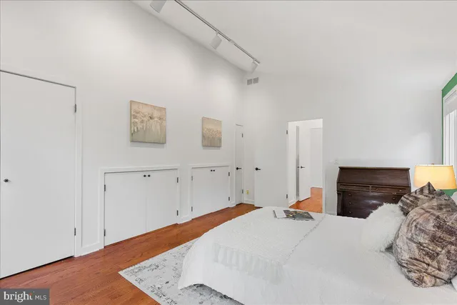 a bedroom with a bed and a lamp on the dresser