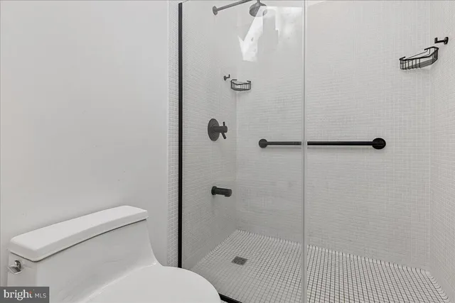 a white toilet sitting next to a bath tub shower