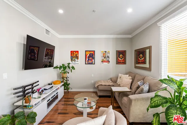 a living room with furniture and paintings on the wall