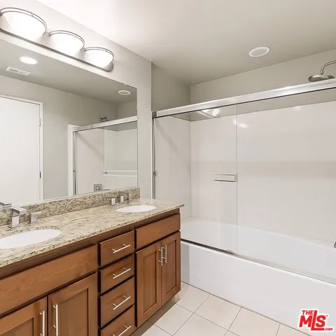 a bathroom with a granite countertop sink a mirror and a bathtub