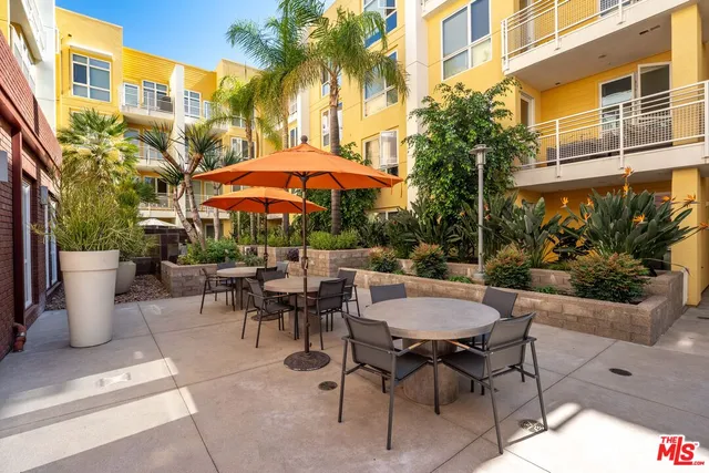 a view of a patio with a table and chairs under an umbrella