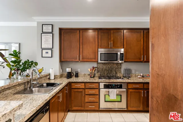 a kitchen with stainless steel appliances granite countertop a sink stove and cabinets